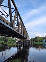 A bridge spans a river with a blue sky in the background