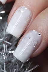 Milky white manicure with glitter on a narrowed nail shape.