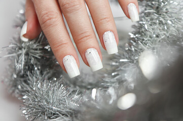 Milky white manicure with glitter on a narrowed nail shape.