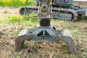 Excavator bucket in front of an excavator at a construction site.