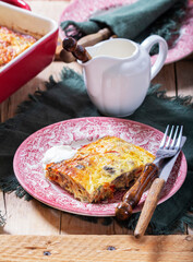 Oven baked omelette with vegetables served with sour cream on wooden background.