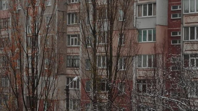 view from window on snowy winter weather in city. Panel high-rise shabby house in soviet style old residential area in ukraine. Architecture of eastern europe and soviet union