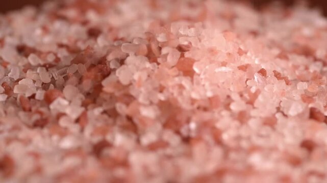 Pink himalayan salt in full screen. Pink salt stones in close up. Pink himalayan rare salt crystal cloce-up background. Spice and vegetarian concept.