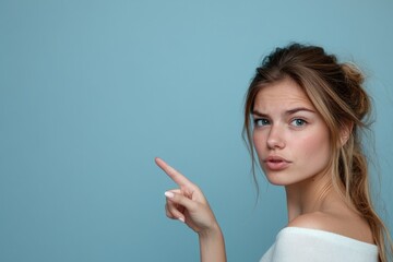 A woman gesturing with her finger towards an unseen object, great for highlighting or emphasizing a point