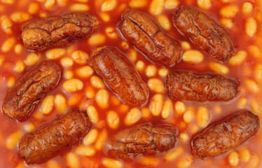 Pork sausages with baked beans in tomato sauce background