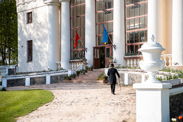 Neoclassical Building with Flags and Formal Attire in Foreground