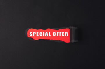 Red and white sign that says Special Offer is cut out of a black background