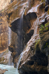 Water jets flowing on wet stones of the response rock. Chegem waterfalls. Fragment. Natural background.