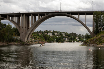 High road bridge over sea bay against cloudy sky