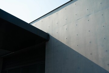 Minimalist concrete wall with dark roofline