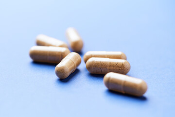 Korean Ginseng capsules. Concept for a healthy dietary supplementation. Bright paper background. Close up.