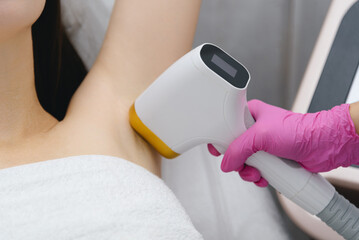 laser epilation, hair removal procedure, young beautiful caucasian smiling brunette woman lying on...