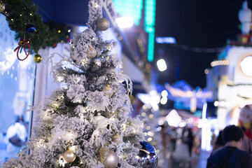 close up snowy Christmas tree with decoration ball and light bulb on festival market mall event...