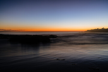 sunset over ocean with mountains