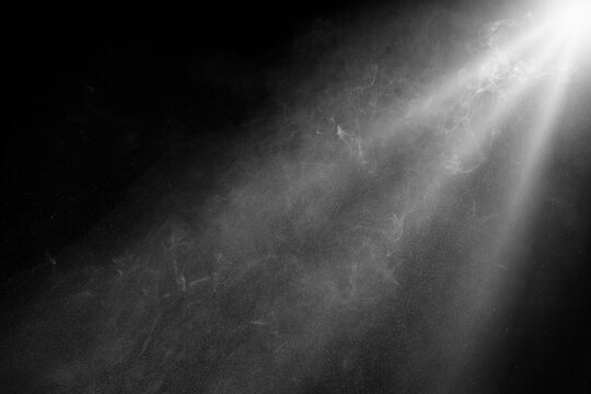 grey spotlight effect on stage or crepuscular rays or gods rays with particles isolated on black background	
