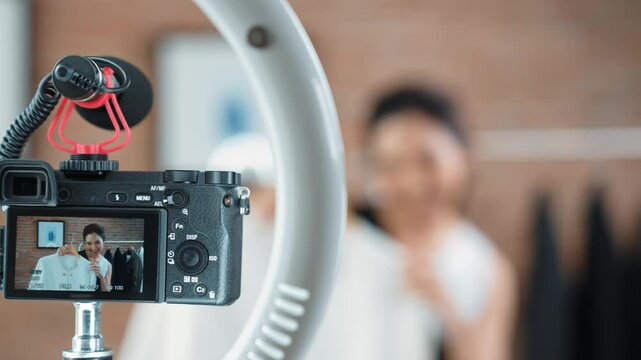 Rear view behide camera screen display woman influencer shoot vlog video review clothes prim social media or blog. Girl with apparel studio lighting for vivancy live streaming marketing recording