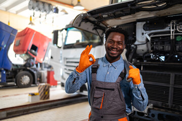 Fototapeta premium Portrait of smiling black maintenance mechanic standing in truck service workshop.
