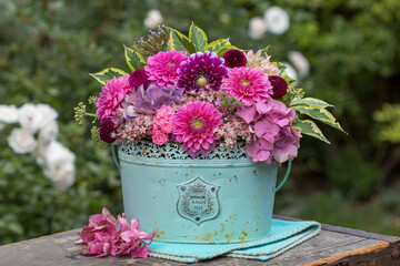 romantischer Blumenstrauß in Pink mit Dahlien und Hortensienblüten im vintage Blumentopf	