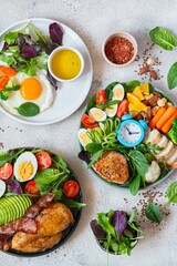 Vegetable plates with meat, fish and eggs. Complete diet for the day. Various breakfasts, lunches, snacks. Time to eat healthy foods. Eating by the hour. Health concept.