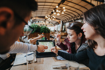 A group of business people engaged in a collaborative meeting outdoors. They are discussing plans while using a tablet, representing teamwork and modern business dynamics.