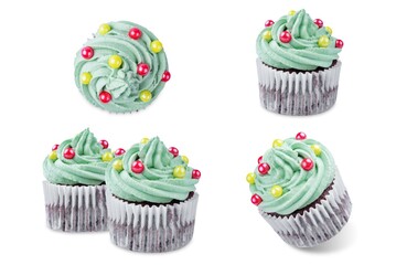 Chocolate cupcakes with green whipped cream topping in the form of Christmas tree for Christmas holidays on a white isolated background