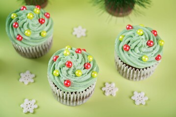 Chocolate cupcakes with green whipped cream topping in the form of Christmas tree for Christmas holidays