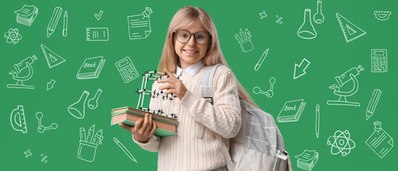 Little schoolgirl with molecular model, books and backpack on green background