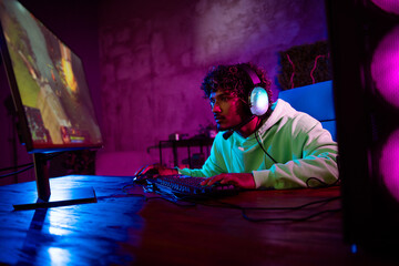 Photo of gamer nice young male focused stressed play computer strategy game late night room indoors...