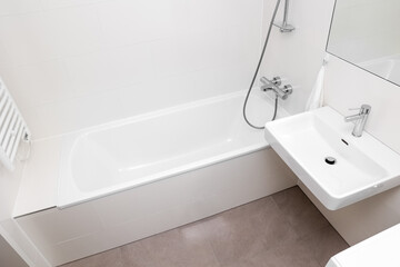 Interior of light bathroom with bathtub and sink