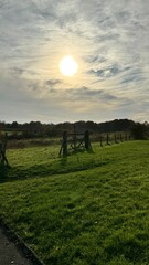 Sunset over the field, wooden fence. England.  Fence for horses. Beautiful sky. Cloudy day. Autumn...