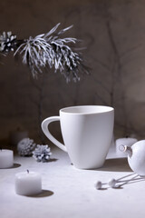 Winter evening composition with a pine branch, a empty cup and candles