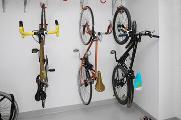 Modern bicycles hanging on light wall