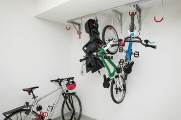 Modern bicycles hanging on light wall