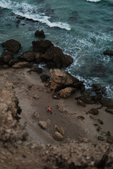 rocks on the beach with running man