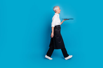 Full size photo of retired female walk profile carry tray barista small coffee shop owner wear...