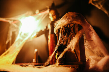 A spooky scene with cobweb covered tombstone, a skull and dim lighting