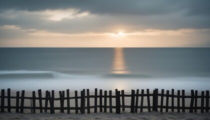 a fence is in front of the ocean at sunset