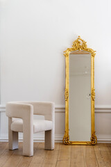 Modern white armchair beside a golden ornate mirror in a stylish living room