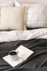 Cozy morning routine with coffee and a book on a comfortable bed