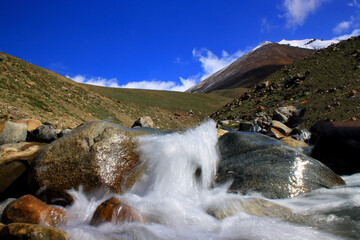 a water stream descending from the high peaks and hills