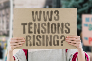The phrase 'WW3 tensions rising?' on a banner in a person's hand. Human holds a cardboard with an inscription. Conflict. Geopolitics. Crisis. Diplomacy. Power. Alliance. Tension