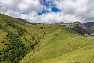 Obraz premium Caucasian mountains near Gergeti village, Stepansminda. Kazbegi mountain behind the clouds. Georgia