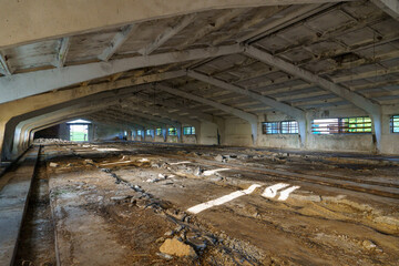 An abandoned destroyed barn, cowshed, warehouse or hangar from the inside. An old abandoned...