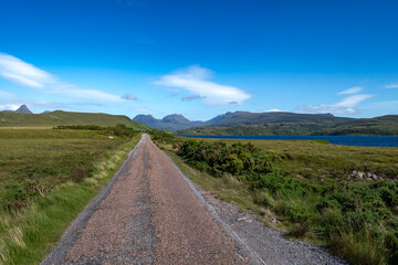 Single Lane Road Through Rural Landscape With Lake Loch Osgaig Near Achnahaird In The Highlands Of Scotland, UK