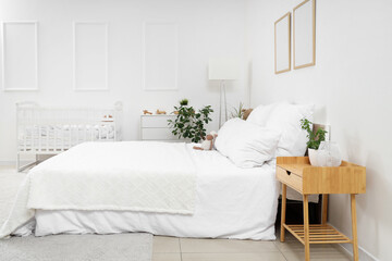 Interior of light children's bedroom with crib and plush toy on cozy bed