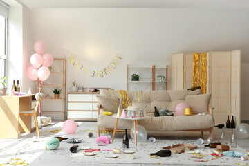 Interior of messy living room after Birthday celebration with sofa, tables and party decor