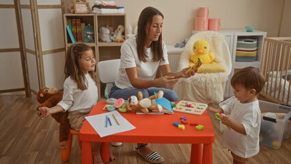 Woman playing with daughter and son in cozy bedroom filled with toys and warm decor, promoting family love and togetherness indoors.
