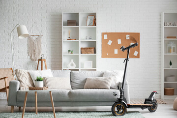 Interior of living room with electric scooter, sofa and shelf units © Pixel-Shot