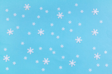 Blue winter background with confetti snowflakes, circles and branches. First snowfall concept. Top...