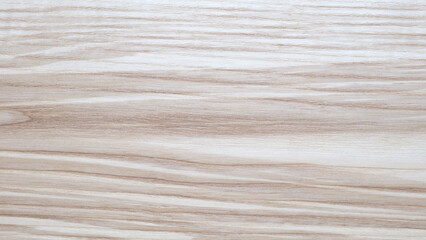 A wooden surface with a grain pattern. The grain is visible in the wood. The surface is light in color